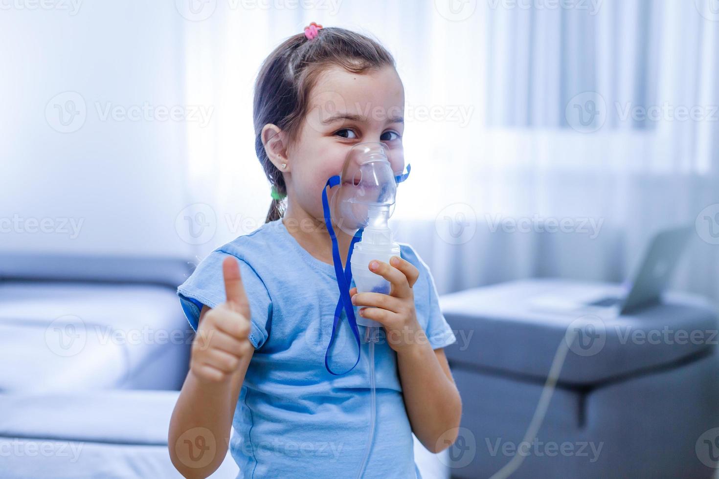 weinig Kaukasisch meisje is ademen met speciaal masker, welke helpt naar hou op astma aanval of verlichten symptomen van ademhalings ziekte. foto