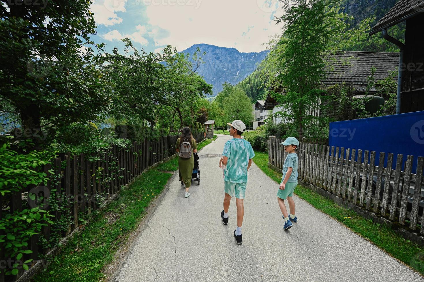 moeder met kinderen wandelen Bij oud stad- hallstatt, oostenrijk. foto