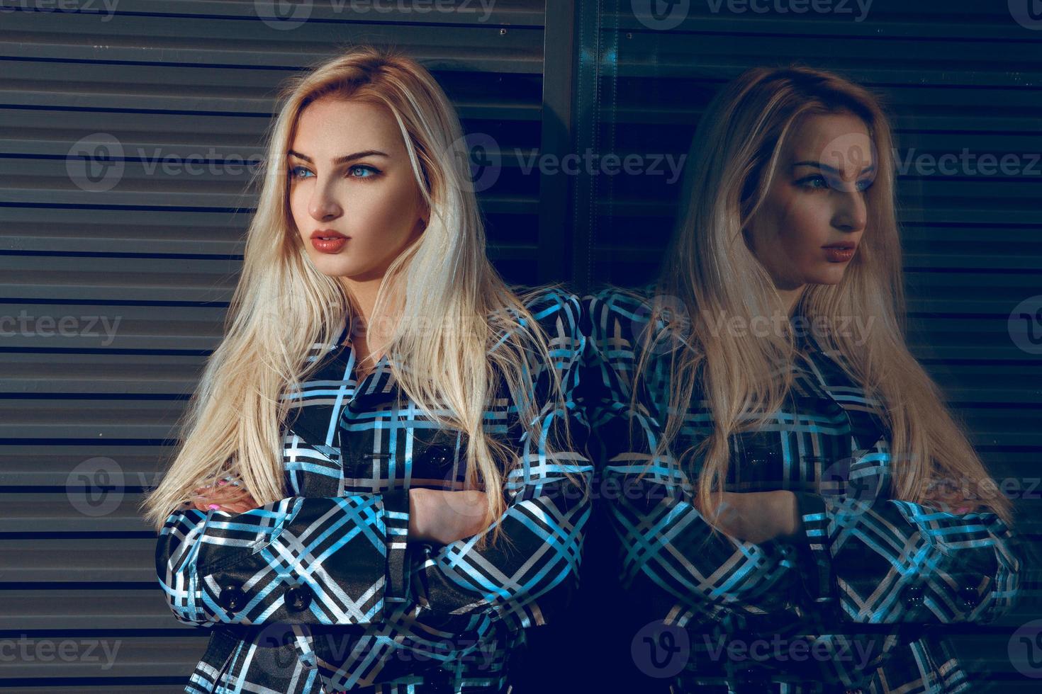 portret van mode jong blond vrouw met blauw ogen op zoek weg in de buurt de groot spiegel foto