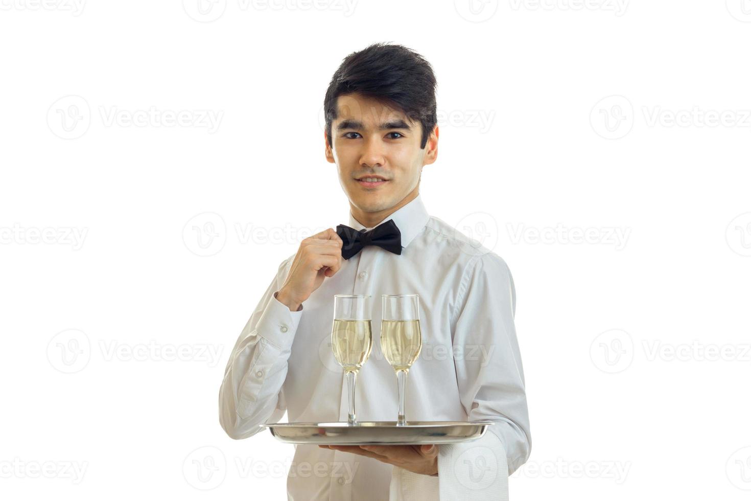 charmant jong ober mooi gekleed Holding een dienblad met bril en past zich aan zijn boog stropdas hand- foto