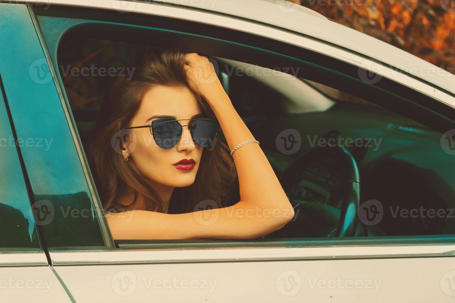 meisje in zonnebril in de auto foto
