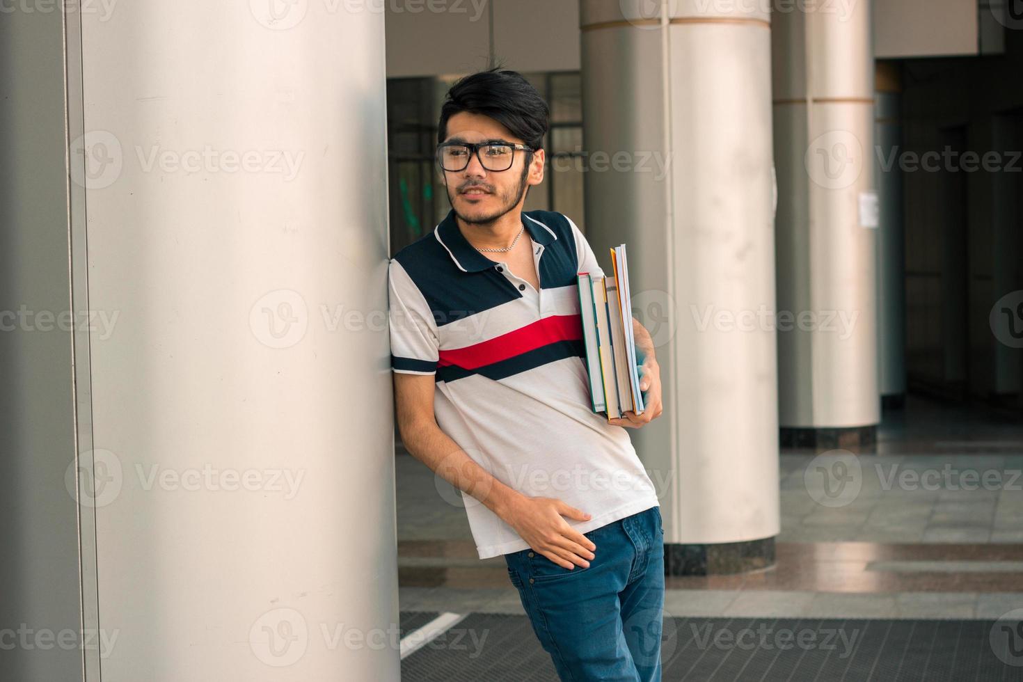 jong leerling jongen in bril met boeken in handen foto