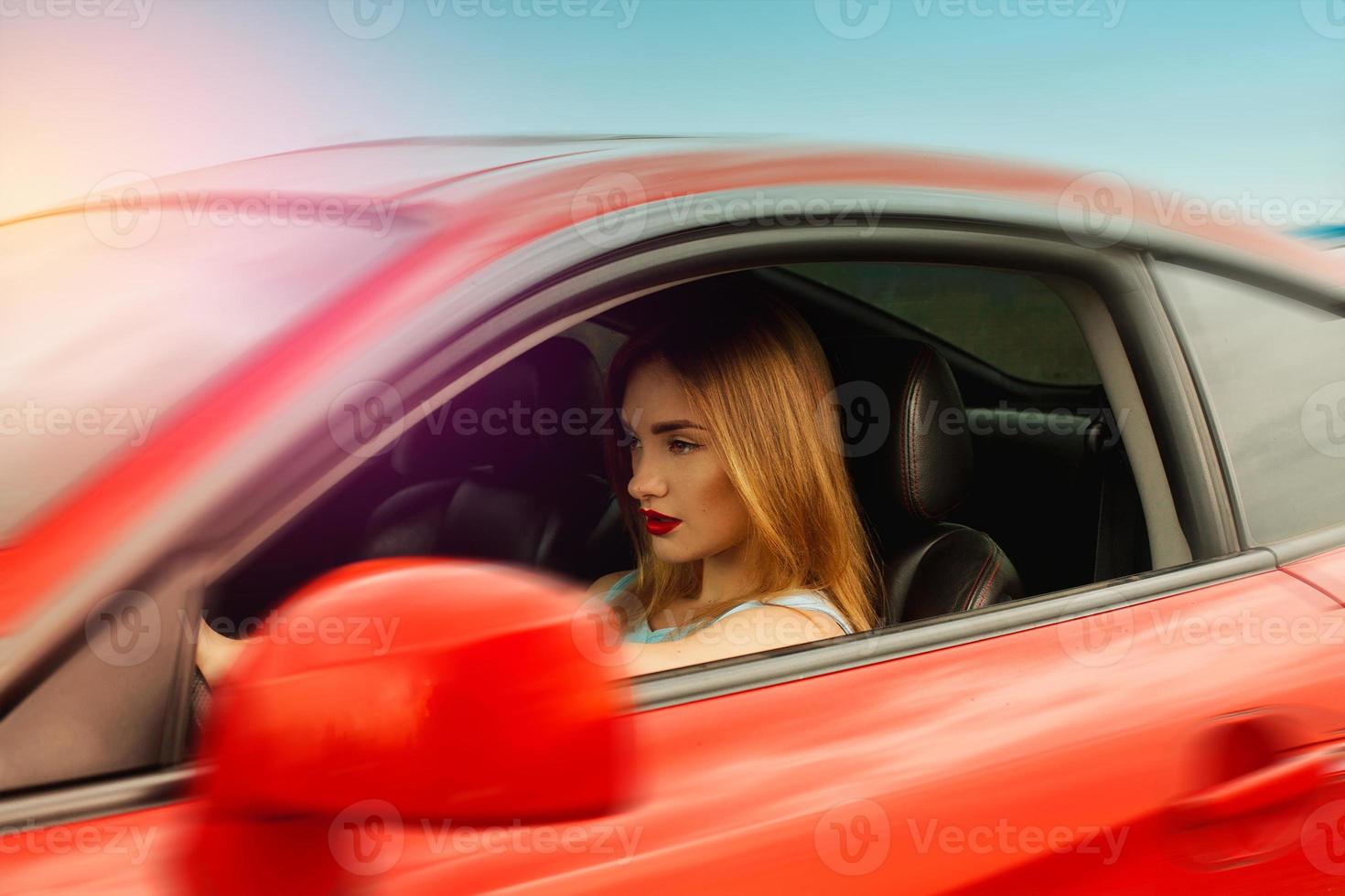 jong vrouw met rood lippen het rijden een auto foto