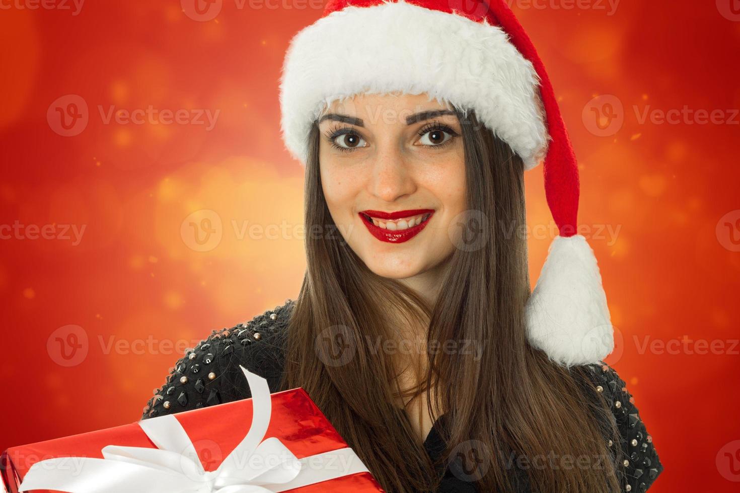 meisje in de kerstman hoed met rood geschenk doos foto