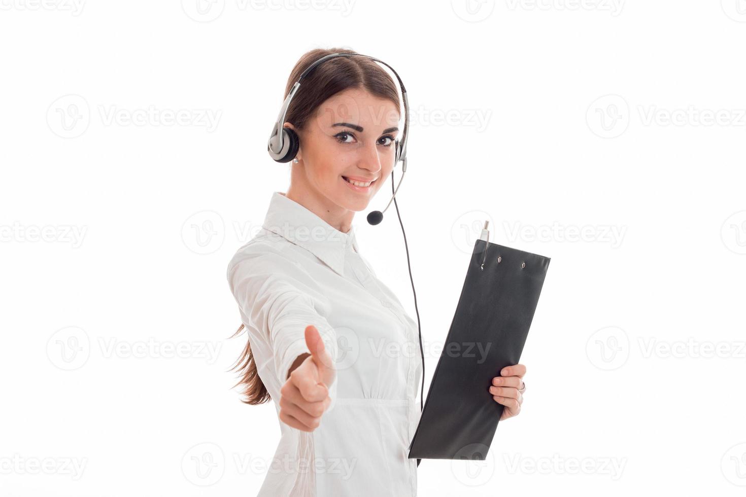 jong meisje in wit overhemd en koptelefoon Holding een tablet voor papieren en shows gebaar klasse foto