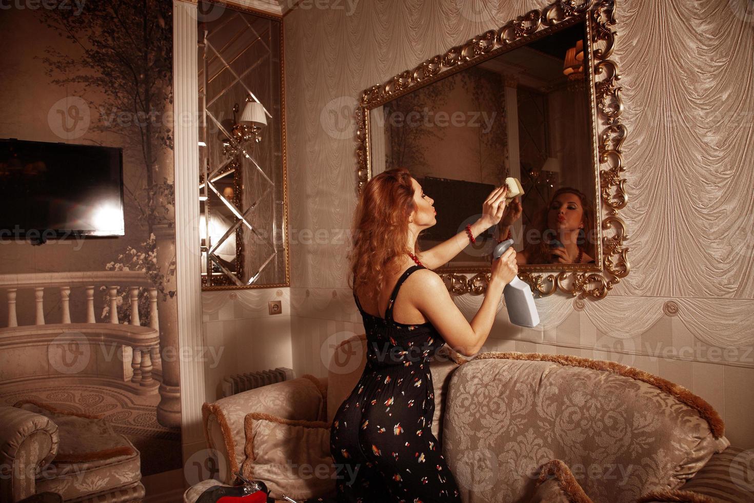 jong sexy rood haar- meisje schoonmaak kamer foto