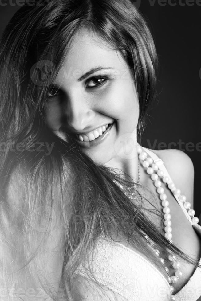 zwart en wit portret van mooi vrouw met toothy glimlach foto