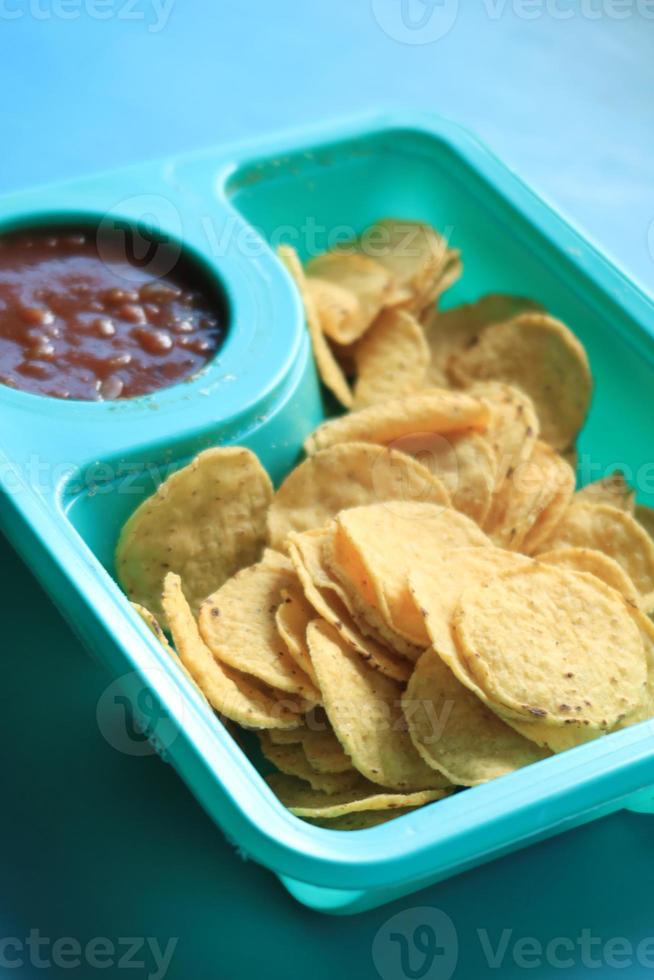 een kom chips en salsa op tafel, foto