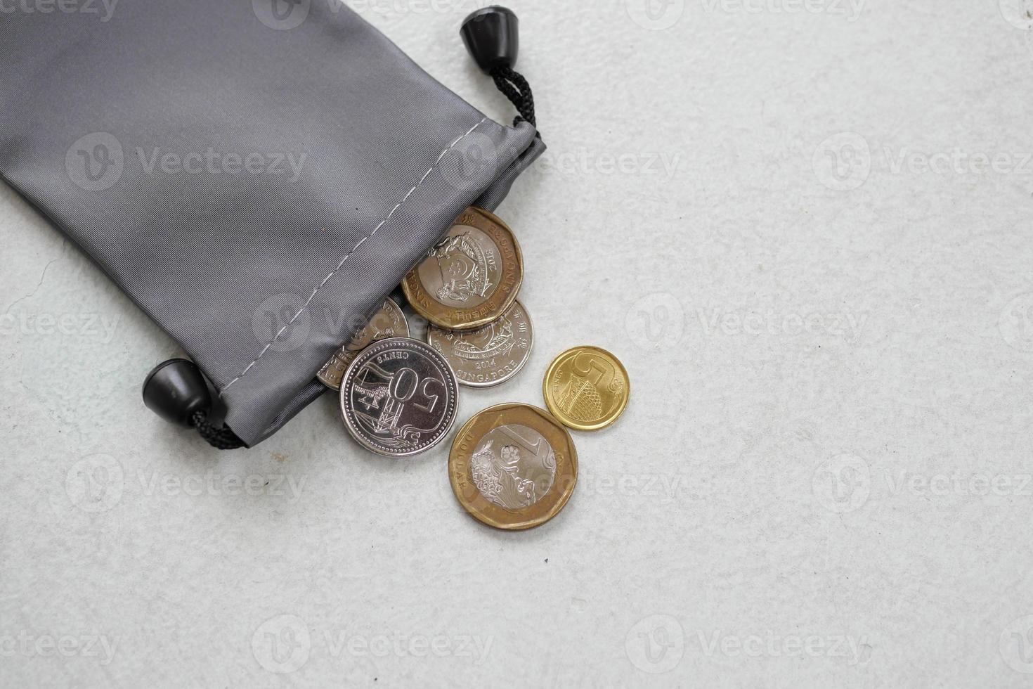 bovenaanzicht van munten die uit een zakje morsen foto