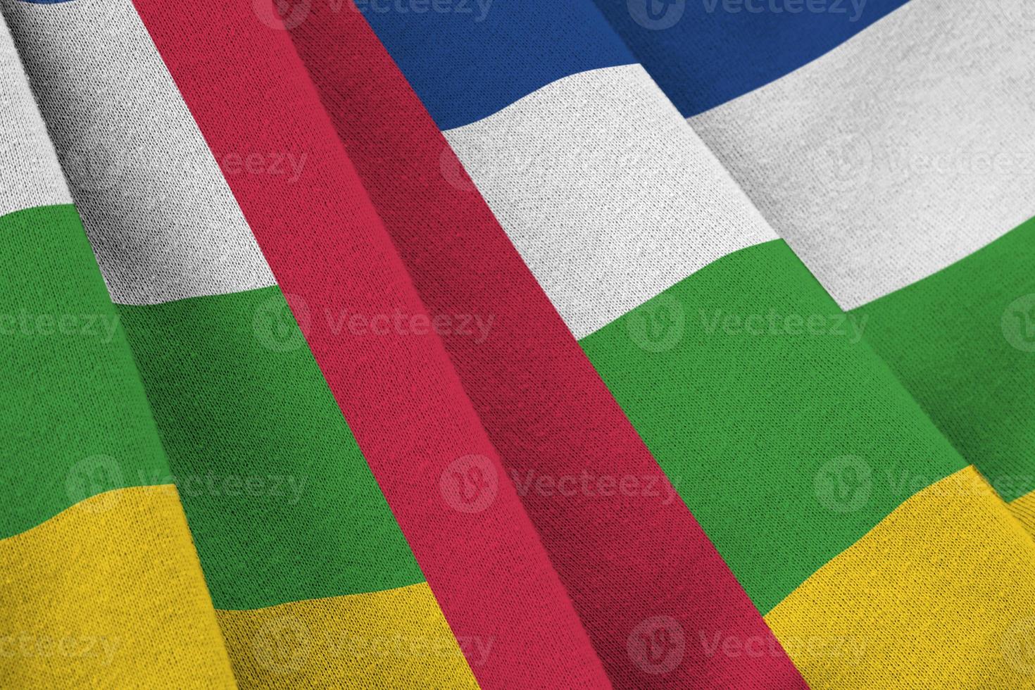 centraal Afrikaanse republiek vlag met groot vouwen golvend dichtbij omhoog onder de studio licht binnenshuis. de officieel symbolen en kleuren in banier foto