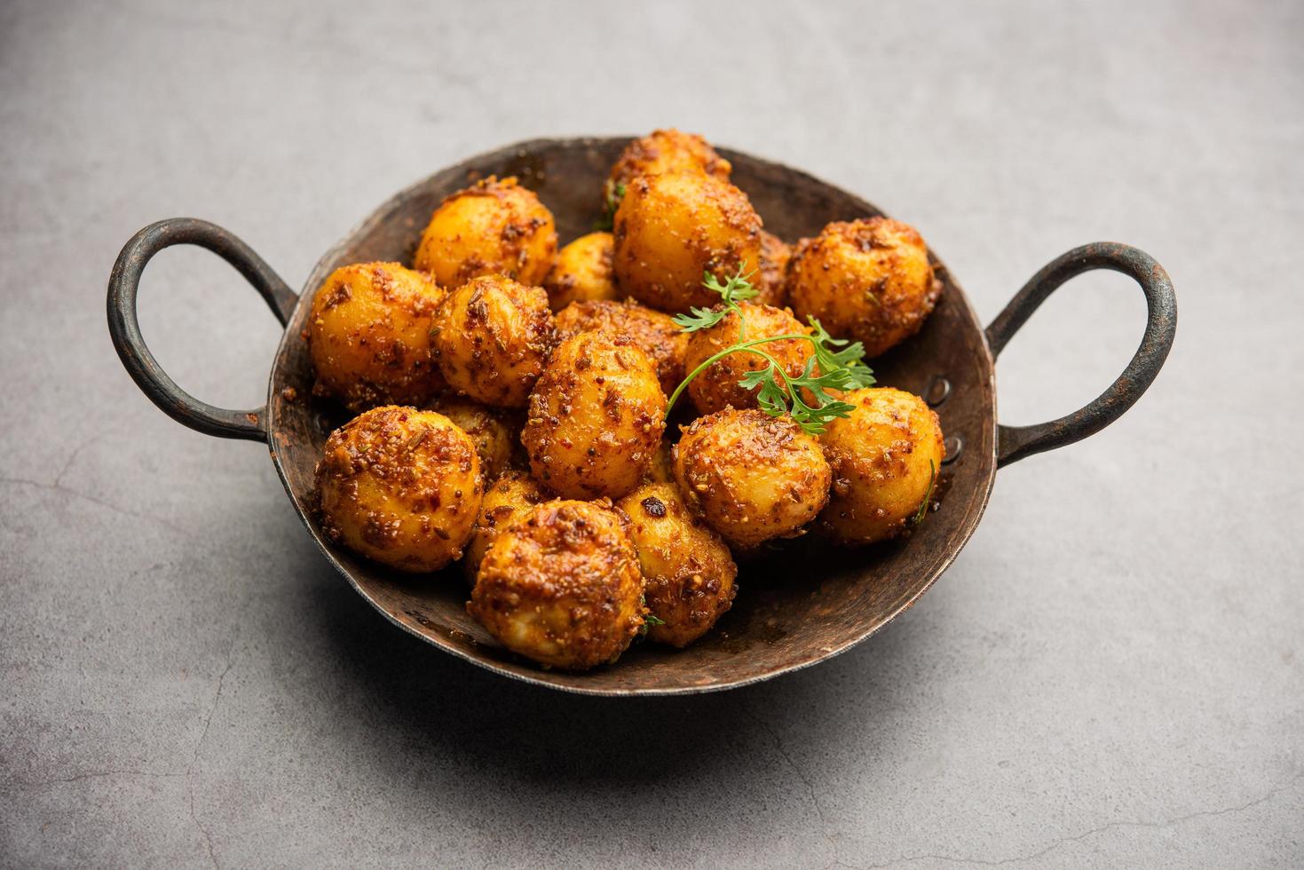 eigengemaakt geroosterd Bombay aardappelen. pan gebakken weinig baby aardappelen of aloo met jeera zaden en koriander in kom foto