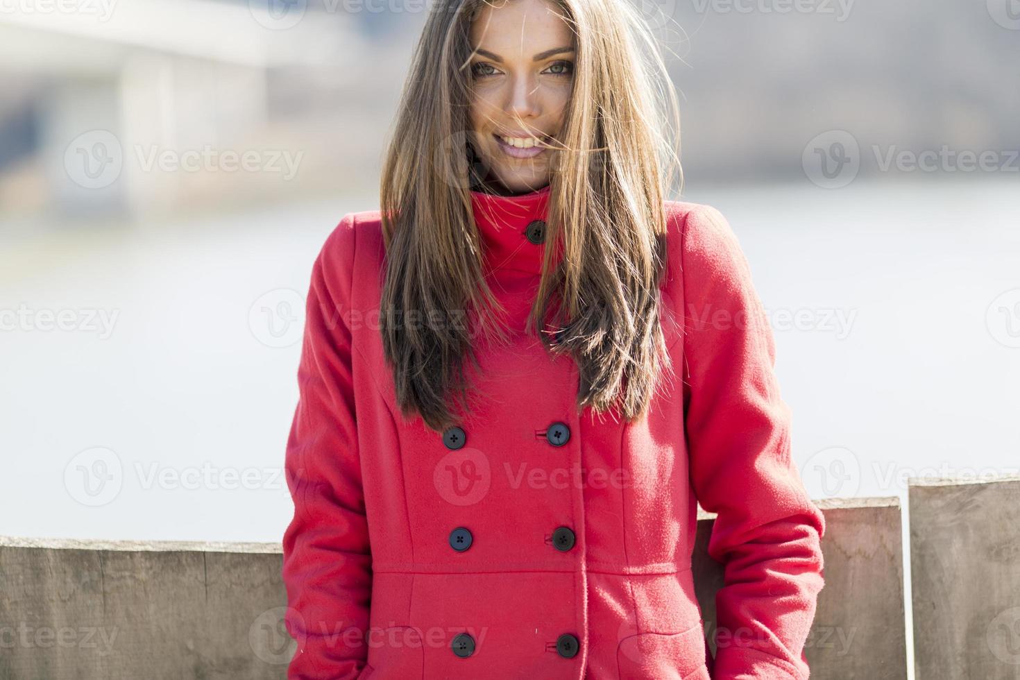 mooi jong vrouw in rood jas foto