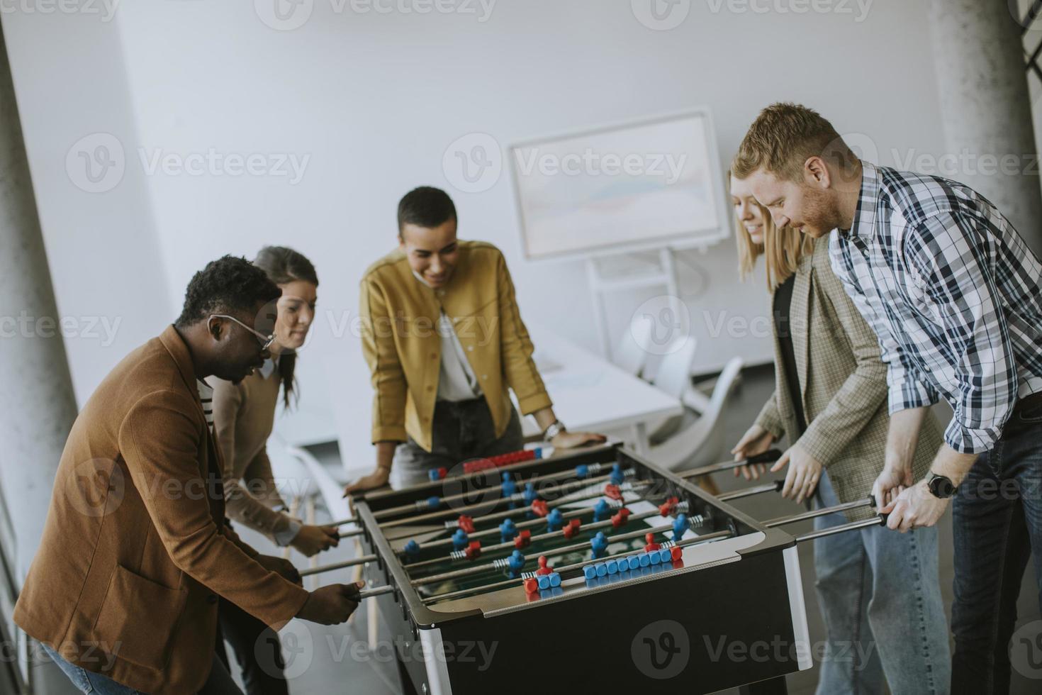 jong gewoontjes multi-etnisch bedrijf mensen spelen tafel Amerikaans voetbal en ontspannende Bij kantoor foto