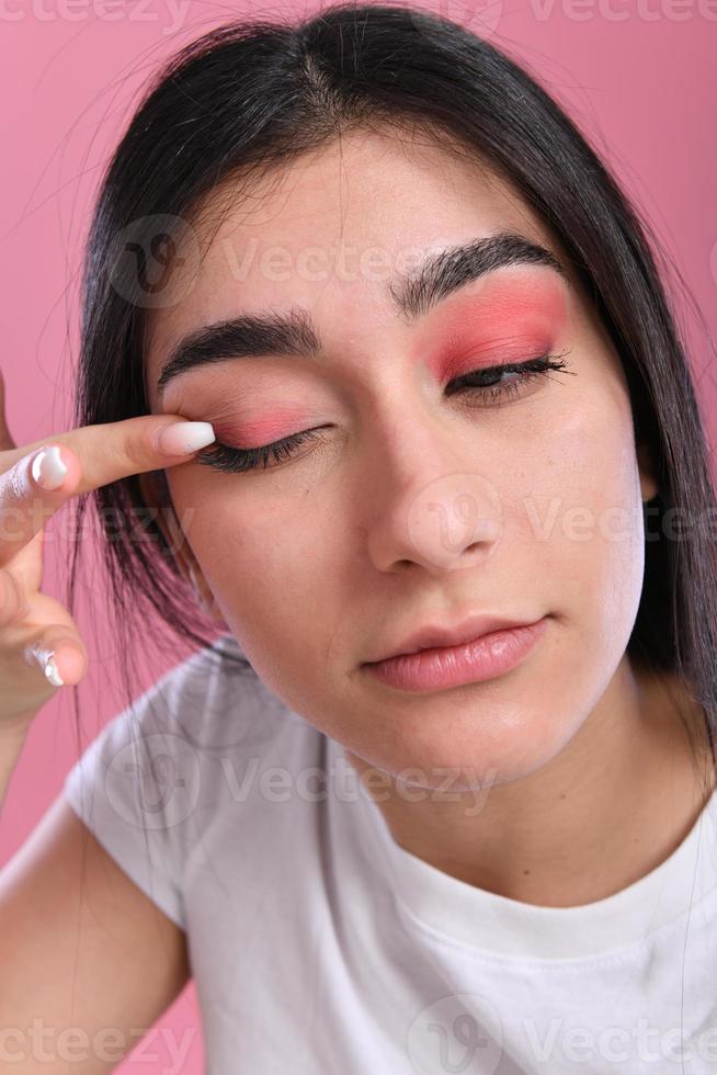 vrouw aan het doen maken omhoog, op zoek Bij spiegel. foto