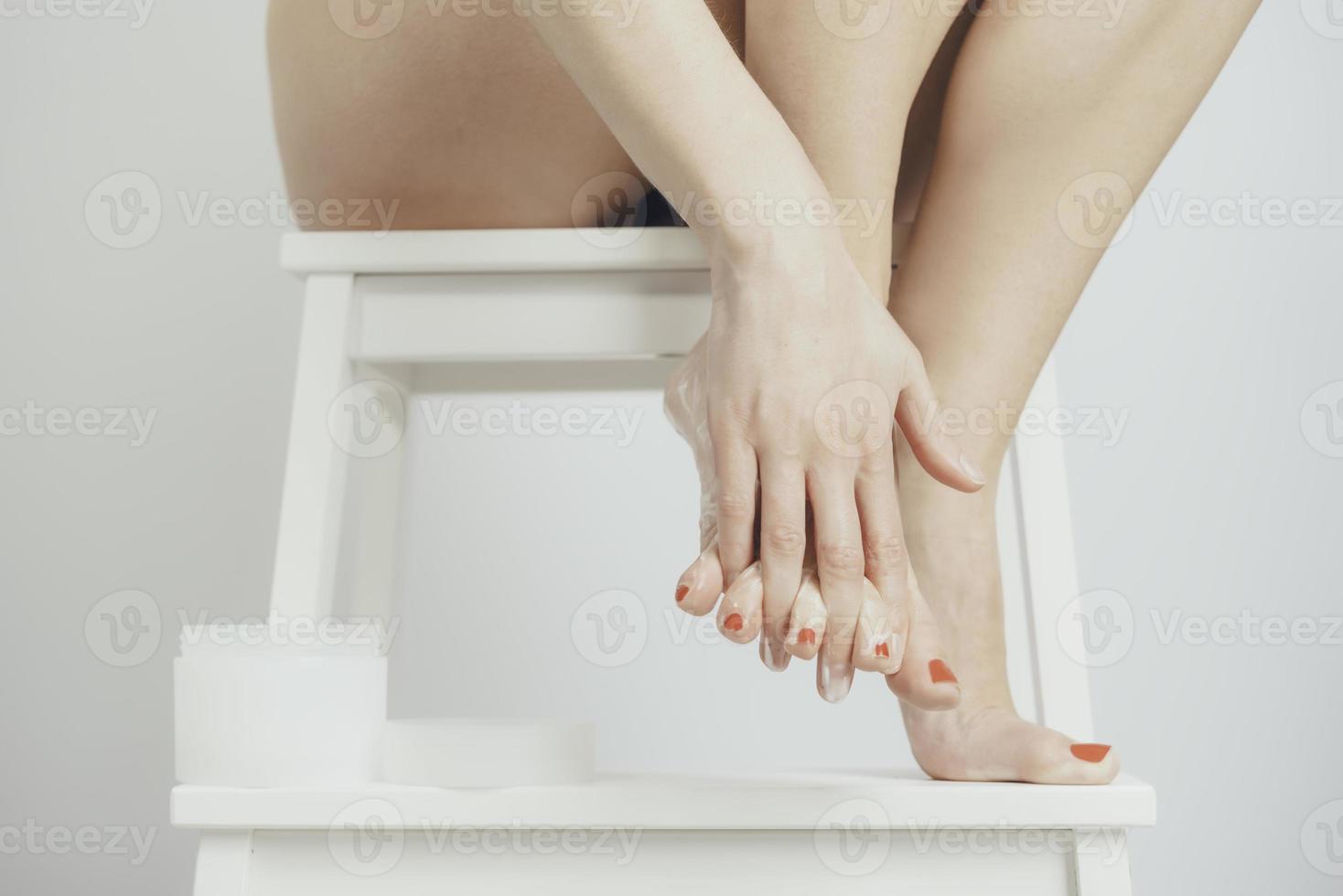 een jong vrouw is van toepassing lotion naar haar voeten foto