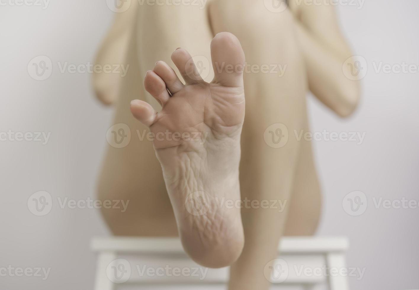 een jong vrouw is van toepassing lotion naar haar voeten foto