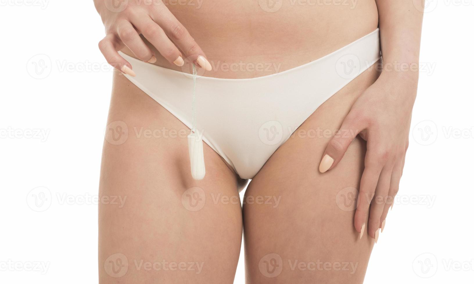vrouw periode en intiem hygiëne. detailopname bijgesneden visie van jong vrouw in wit slipje Holding tampon foto