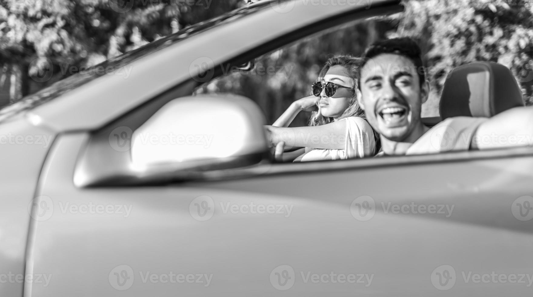 vrienden hebben pret Bij auto reis in de omgeving van de wereld. paar in liefde met armen omhoog Aan een converteerbaar auto. foto