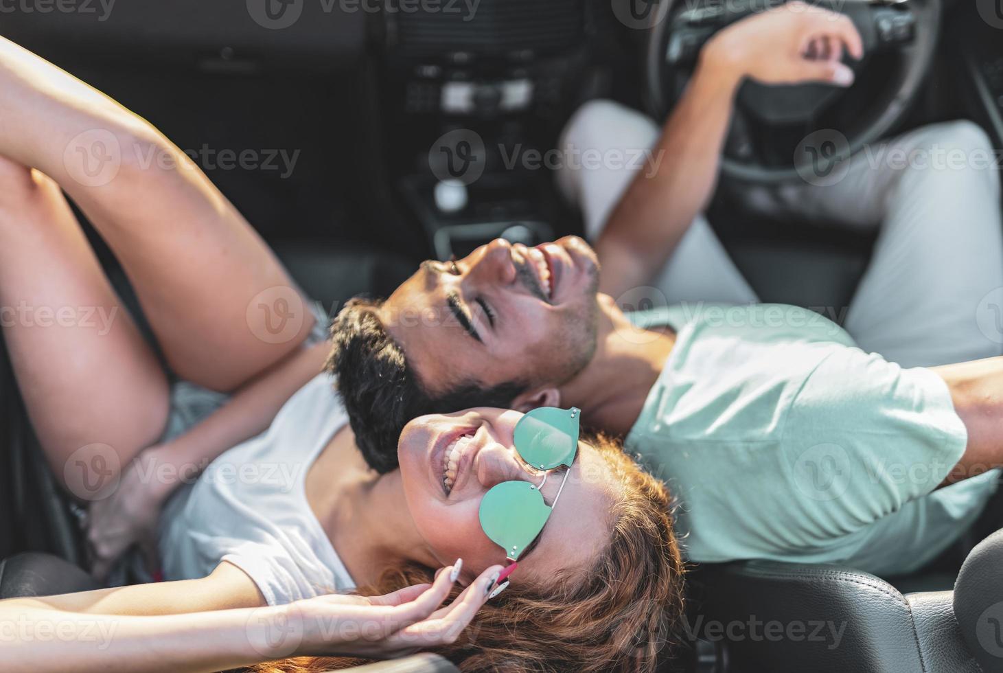 vrienden hebben pret Bij auto reis in de omgeving van de wereld. paar in liefde met armen omhoog Aan een converteerbaar auto. foto