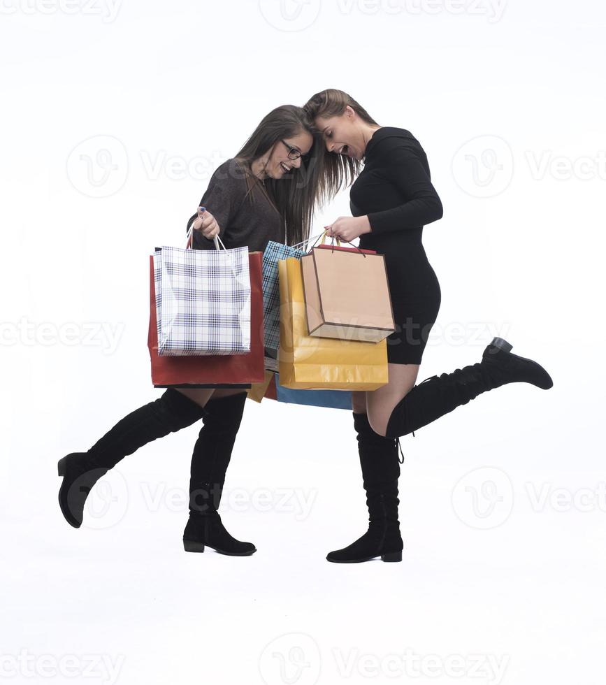 twee gelukkig vrouw vrienden met boodschappen doen zak Aan geïsoleerd studio achtergrond. foto