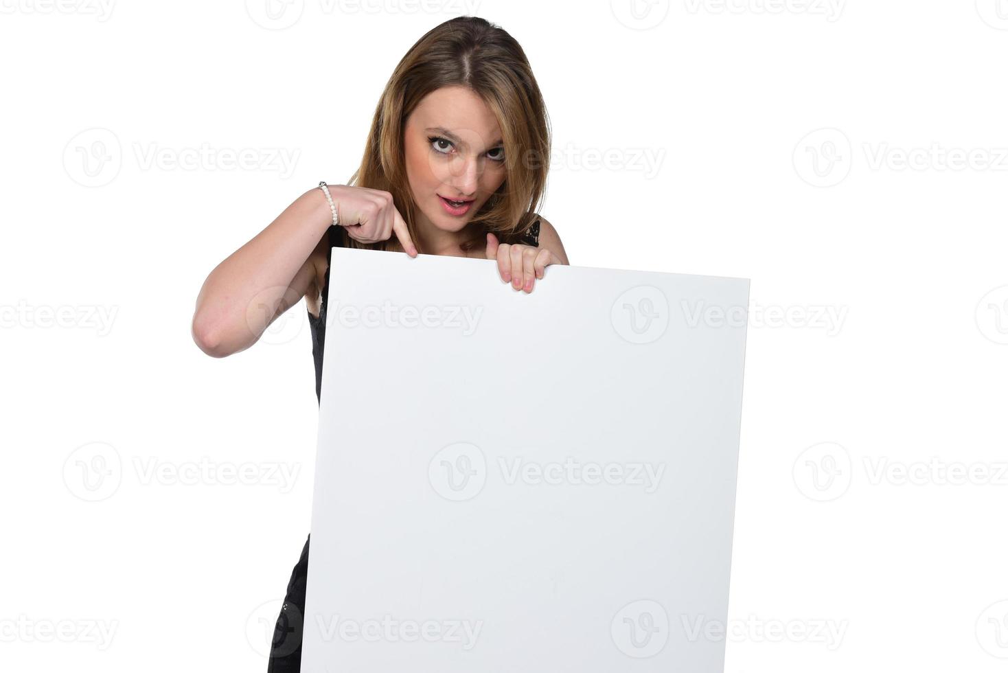 portret van jong mooi vrouw piepen Bij de camera Holding wit blanco teken tonen Aan het met vinger geïsoleerd Aan wit foto