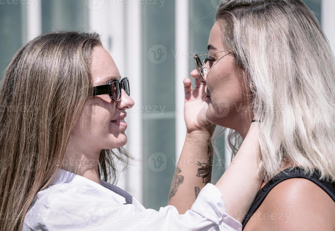 een paar van homo vrouw glimlachen en kussen. dezelfde seks jong getrouwd vrouw paar in hun dagelijks routine- tonen sommige genegenheid lgbt foto