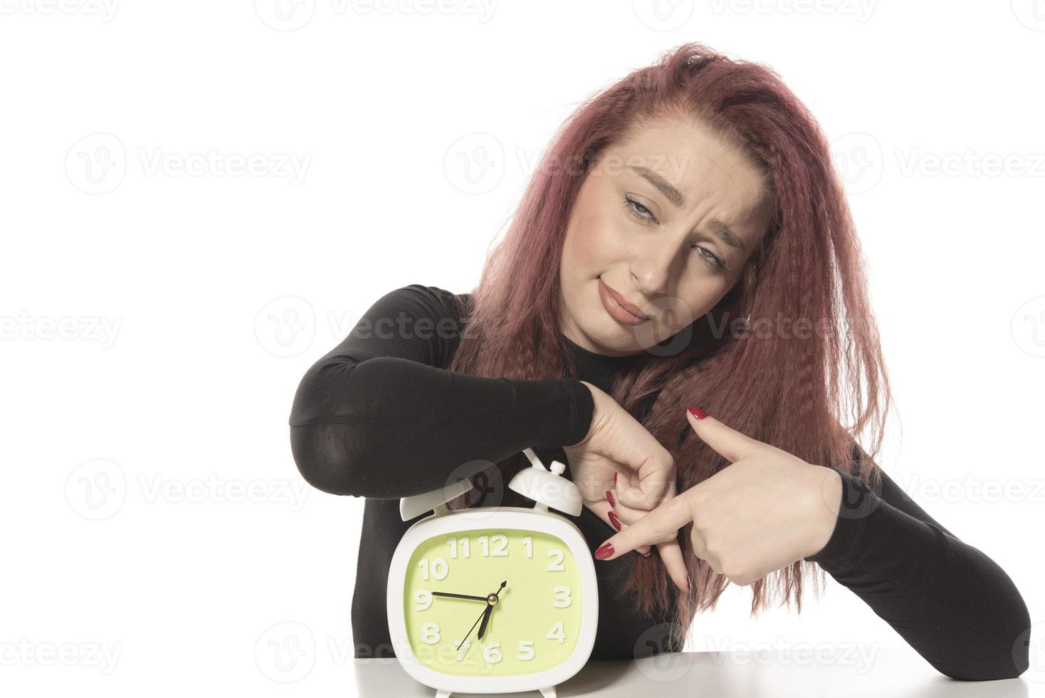 bezorgd jong vrouw Holding alarm klok in haar hand- foto