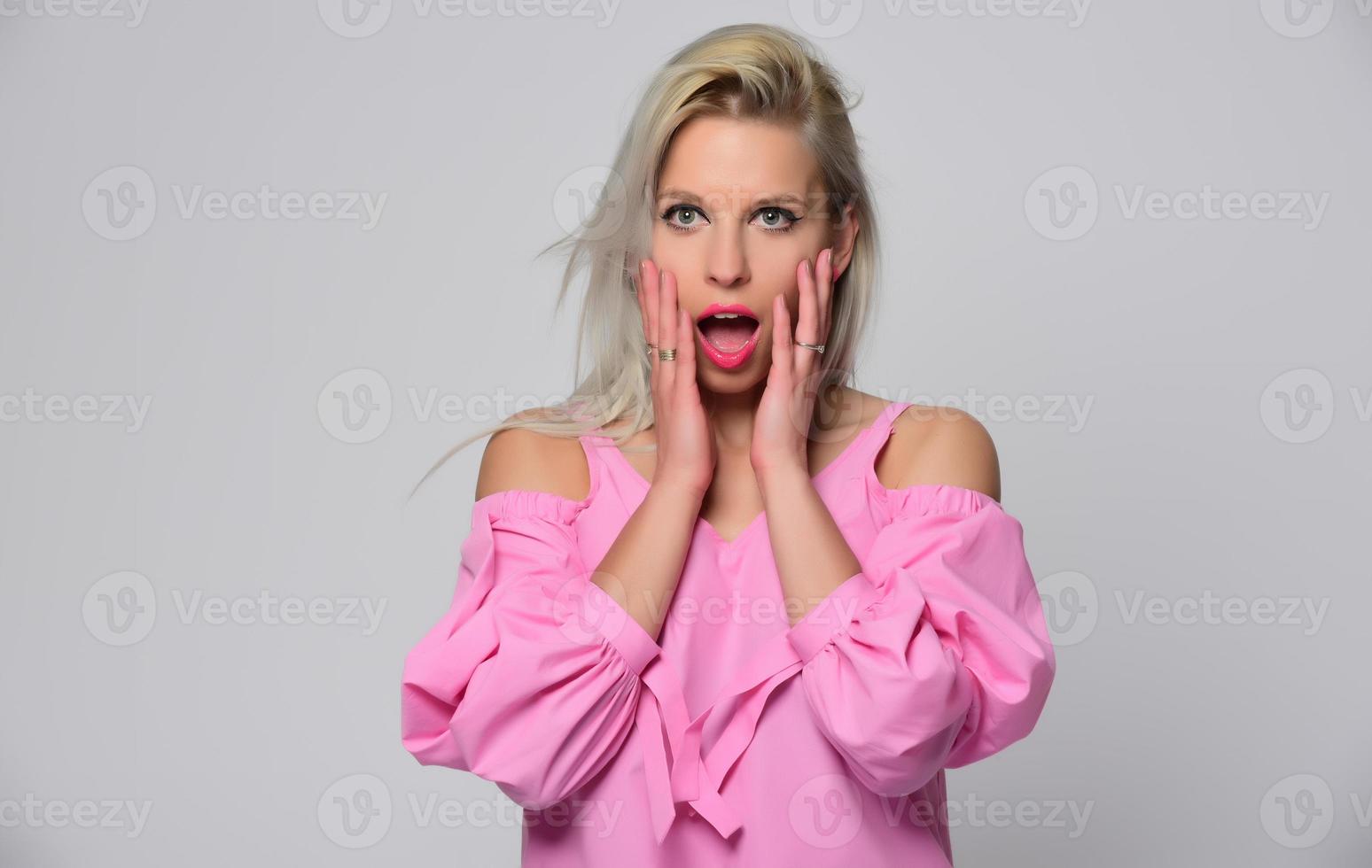 portret van mooi jong vrouw in schattig roze overhemd en blauw jeans poseren in studio. concept van schoonheid, emoties, gelaats uitdrukking, levensstijl, mode, jeugd cultuur foto