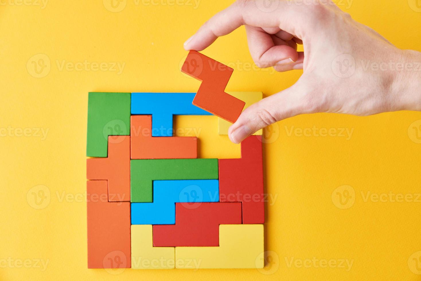 vrouw hand- toevoegen laatste missend houten blok naar af hebben puzzel foto