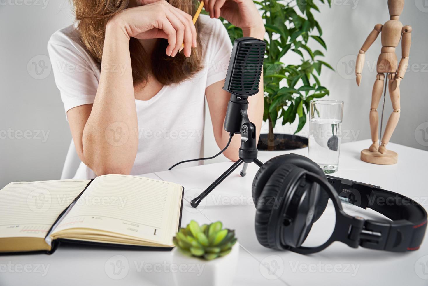 vrouw opname online podcast Bij huis. microfoon en hoofdtelefoons Aan tafel foto