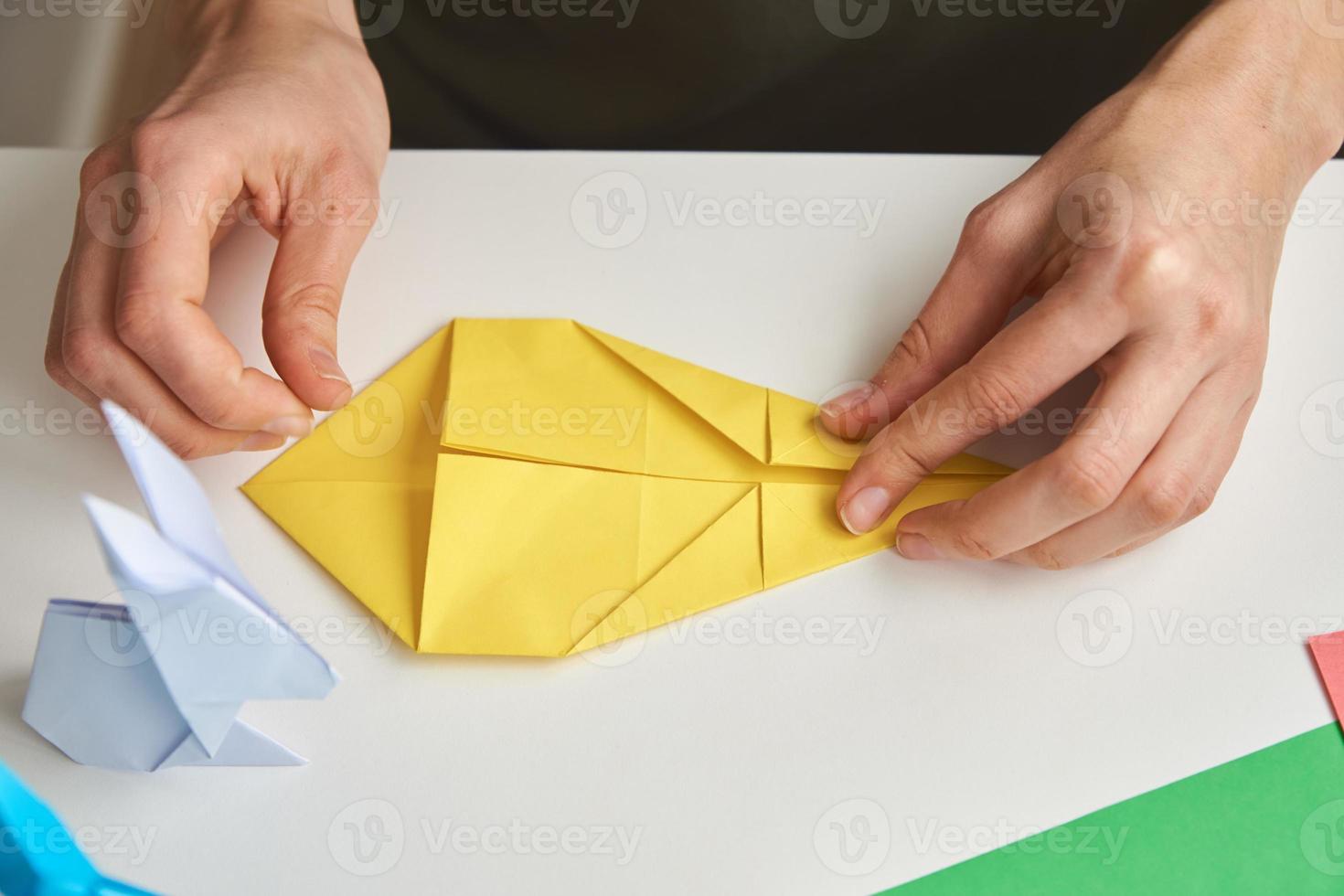 diy concept. vrouw maken origami Pasen konijn van kleur papier. origami lessen foto