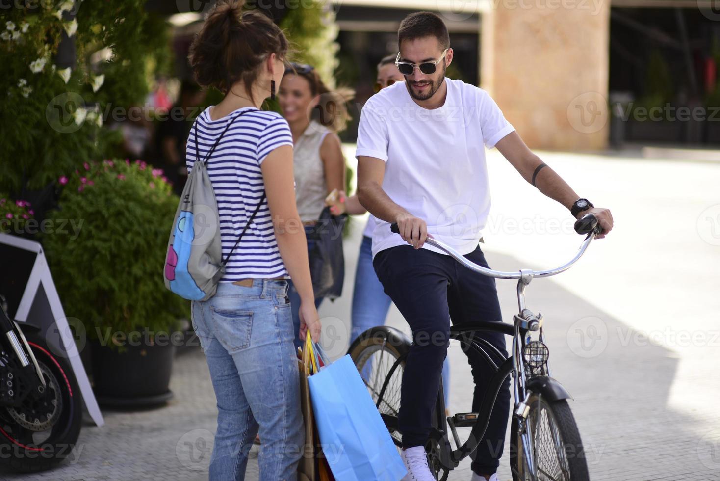 portret van vrolijk Kaukasisch jong paar Mens en vrouw Holding veel papier Tassen na boodschappen doen terwijl wandelen en pratend Aan straat. gelukkig familie paar met pakketjes buitenshuis. buying concept foto