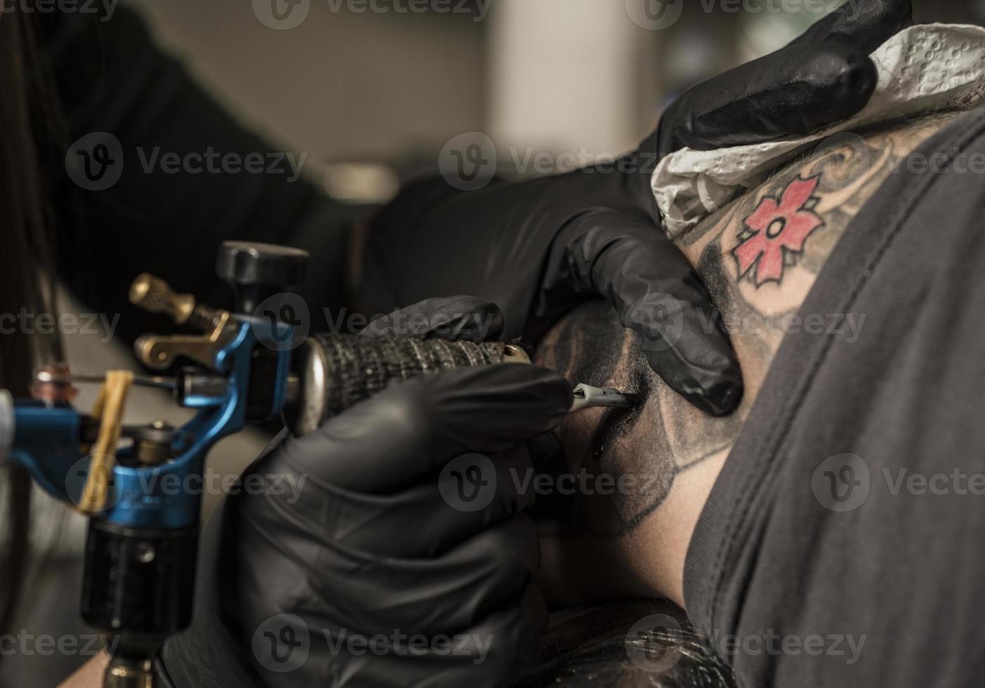 dichtbij omhoog tatoeëren machine. vrouw creëren afbeelding Aan hand- met het in salon foto