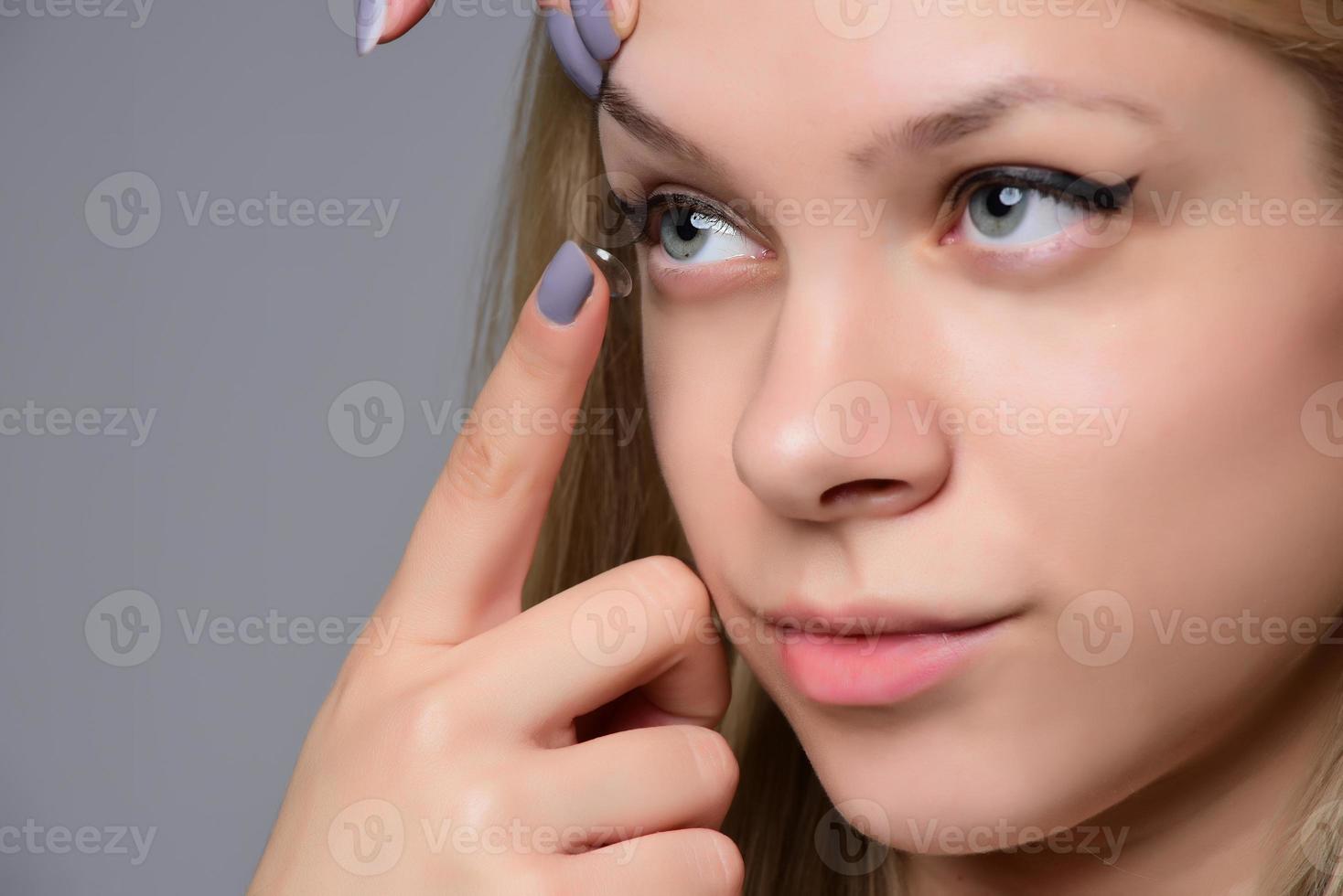 contact lens voor visie. detailopname van vrouw gezicht met toepassen contact lens Aan haar bruin ogen. mooi vrouw zetten oog lenzen met handen. oogheelkunde geneeskunde en Gezondheid. hoog resolutie foto