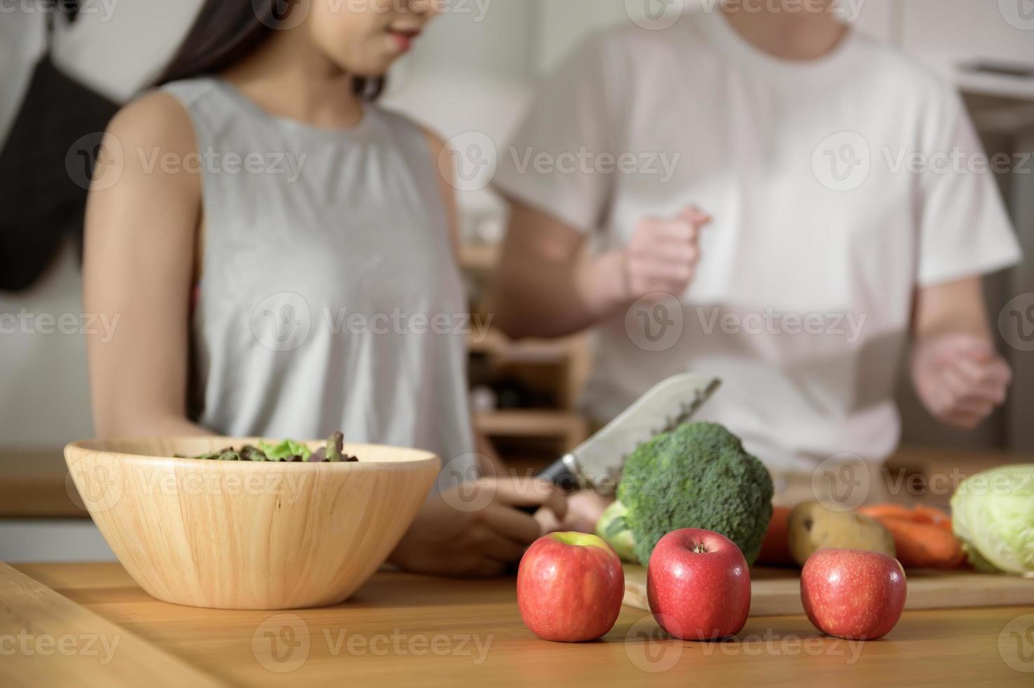 een Aziatisch jong paar genieten Koken met gezond groenten en fruit ingrediënten in keuken Bij huis , gezond welzijn levensstijl concept. foto