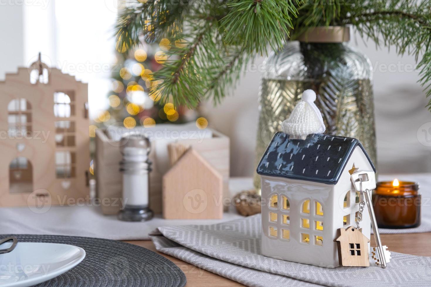 sleutel naar de huis Aan knus huis met Kerstmis decor Aan tafel van feestelijk keuken. geschenk voor nieuw jaar. gebouw, ontwerp, projecteren, in beweging naar nieuw huis, hypotheek, huur en aankoop echt landgoed foto