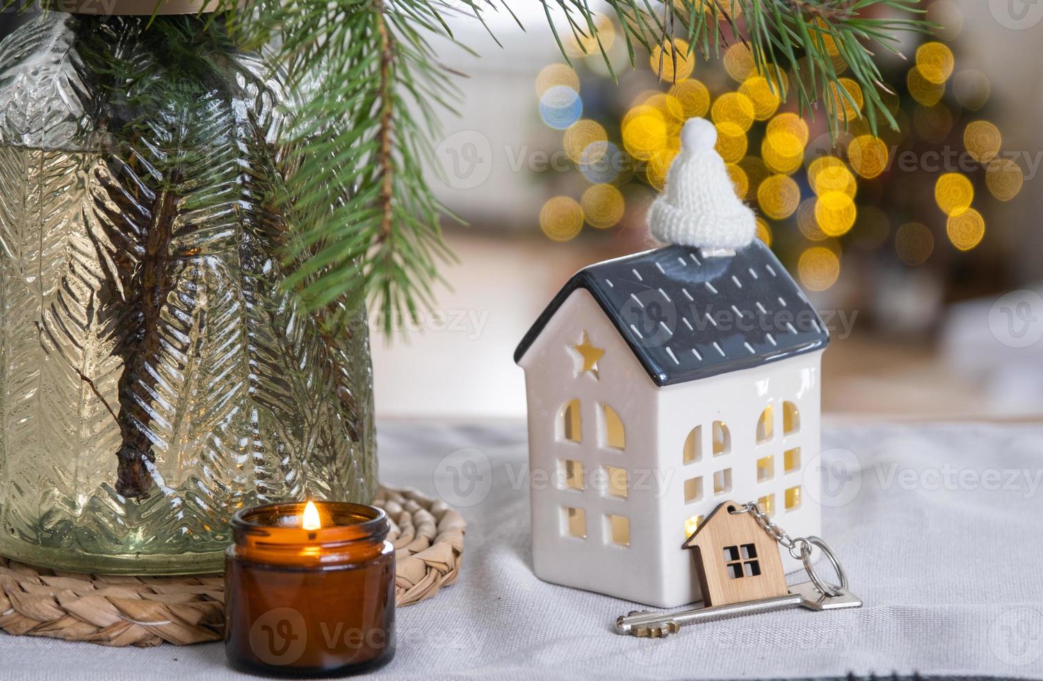 sleutel naar de huis Aan knus huis met Kerstmis decor Aan tafel van feestelijk keuken. geschenk voor nieuw jaar. gebouw, ontwerp, projecteren, in beweging naar nieuw huis, hypotheek, huur en aankoop echt landgoed foto