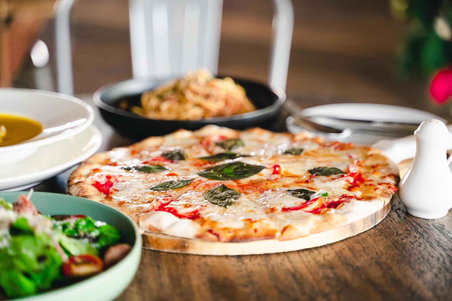 Italiaans voedsel maaltijden Aan de tafel pizza, pasta, soep, groente salade. foto