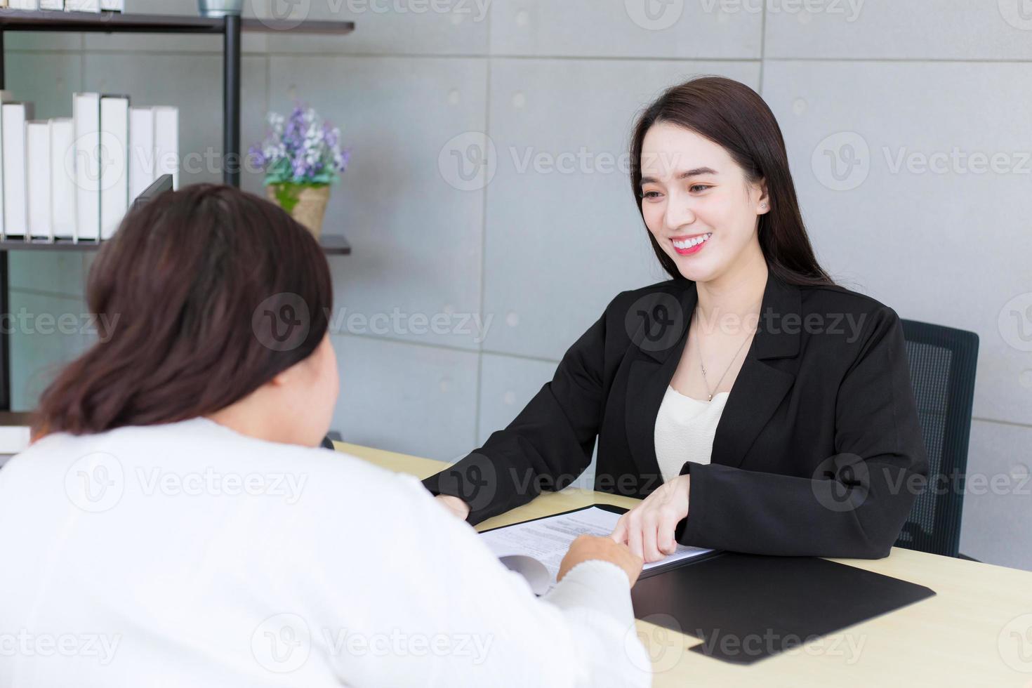 Aziatisch professioneel vrouw is werken en richten zelfverzekerd Aan de papier of document naar bespreken met haar baas Bij kantoor. foto
