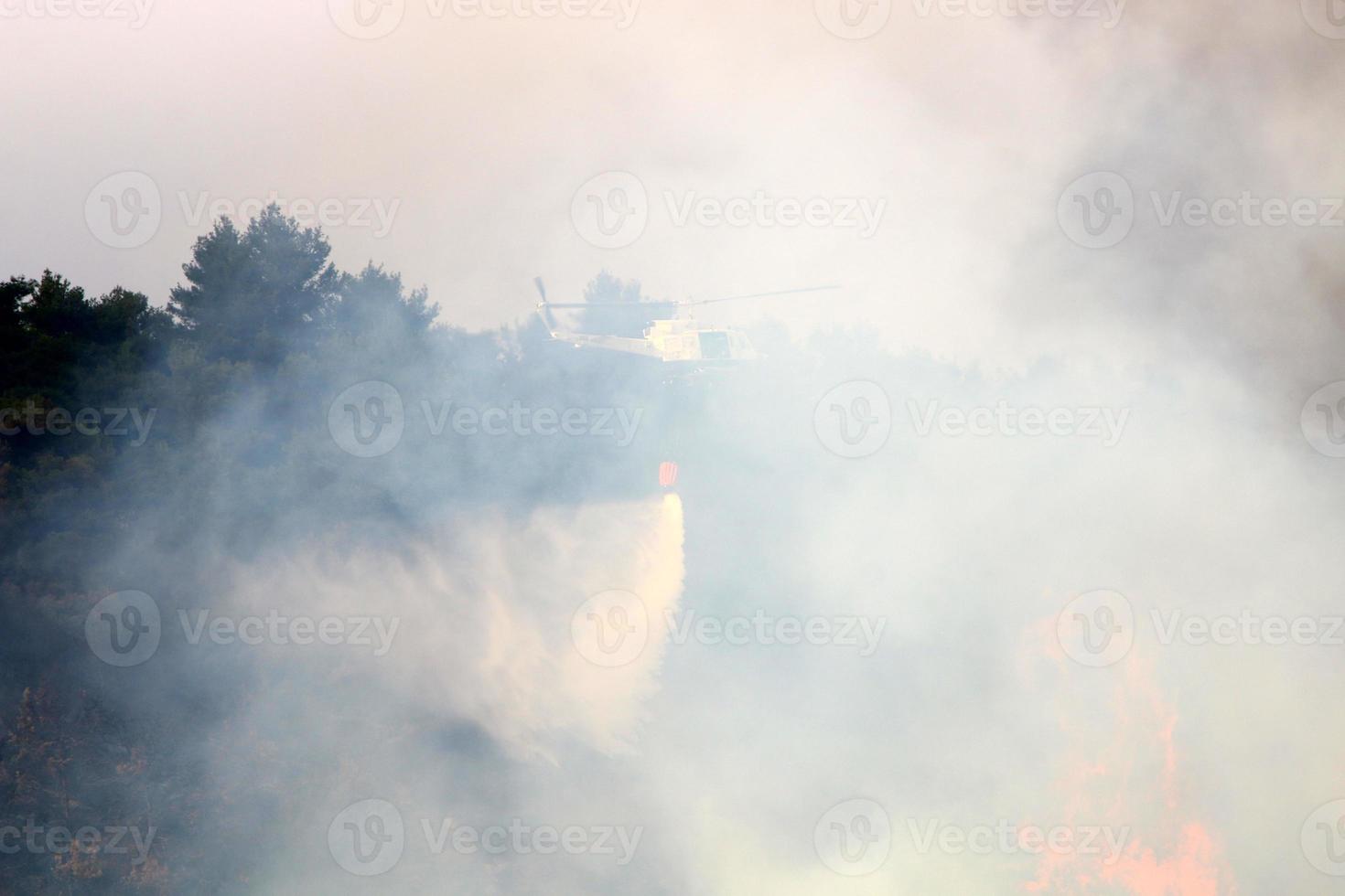 een helikopter zet uit een Woud brand in de bergen van noordelijk Israël. foto