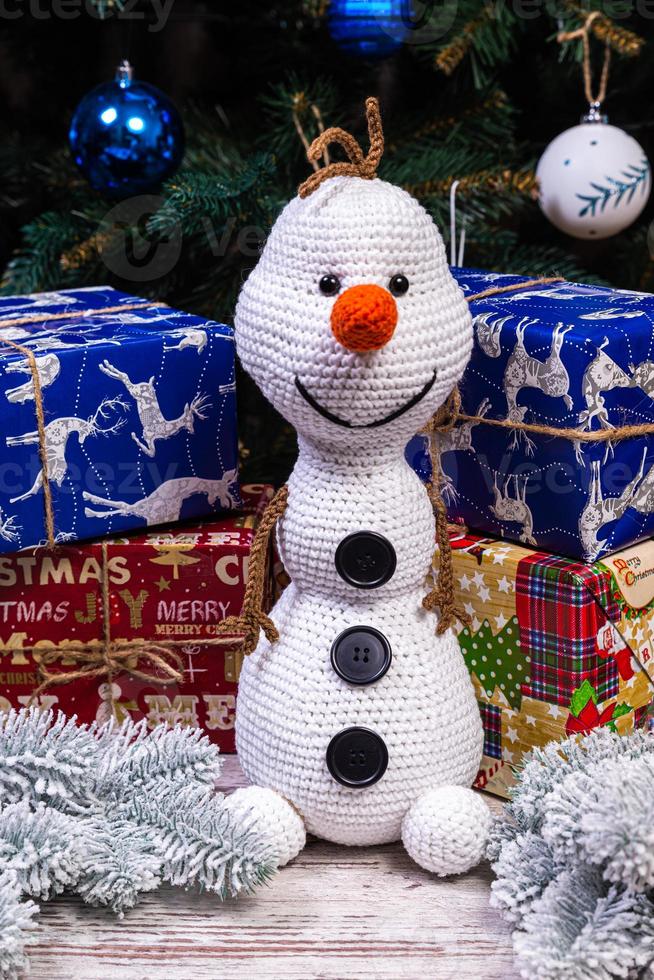 gebreid sneeuwmannen in kleurrijk hoeden en sjaals Aan een blauw achtergrond. de concept van kerstmis, nieuw jaar en winter fee verhaal. foto