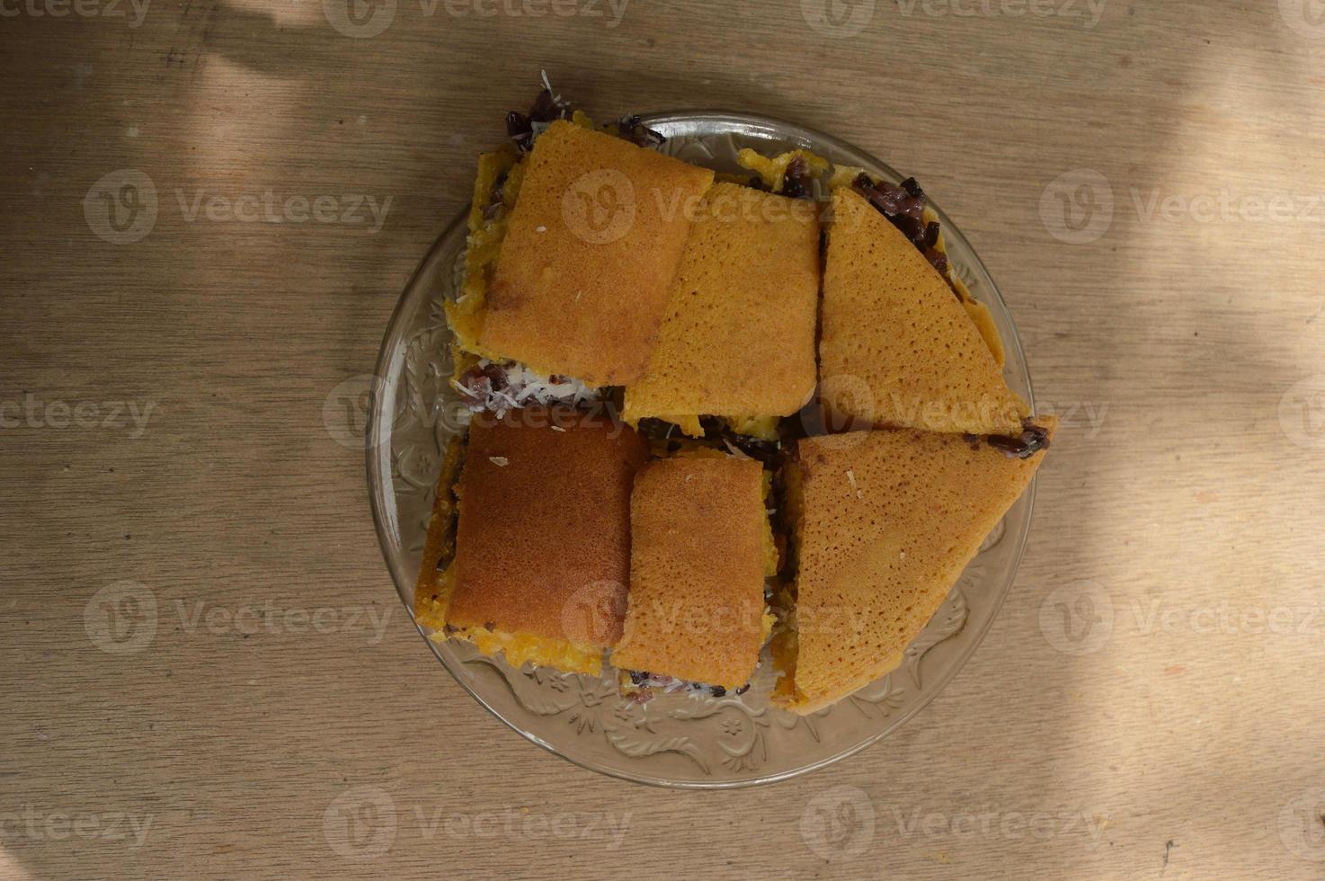 terang bulan voedsel gemaakt van meel en gevuld met zwart kleverig rijst- afkomstig van Indonesië. met borden en houten achtergrond. foto