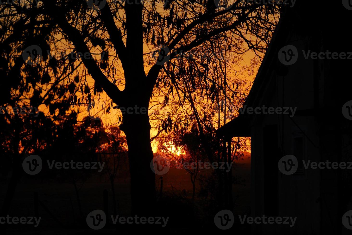 zonsondergang over- een boerderij foto