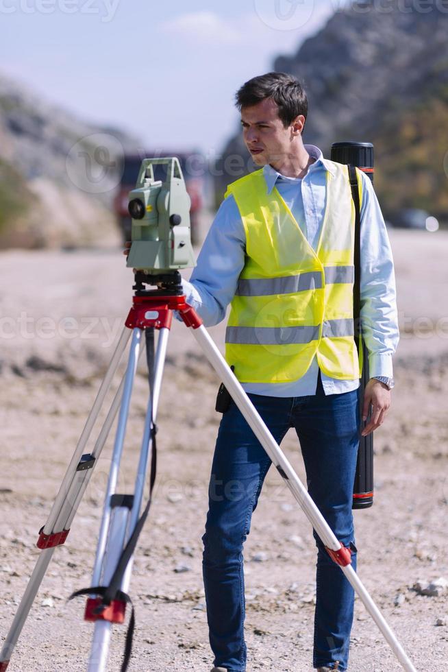 landmeter ingenieur is meten niveau Aan bouw plaats. landmeters ervoor zorgen nauwkeurig metingen voordat onderneming groot bouw projecten. foto