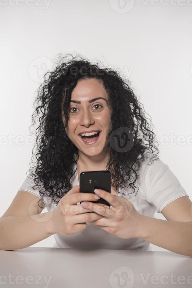 portret van een gelukkig vrouw gebruik makend van mobiel telefoon geïsoleerd over- wit achtergrond foto