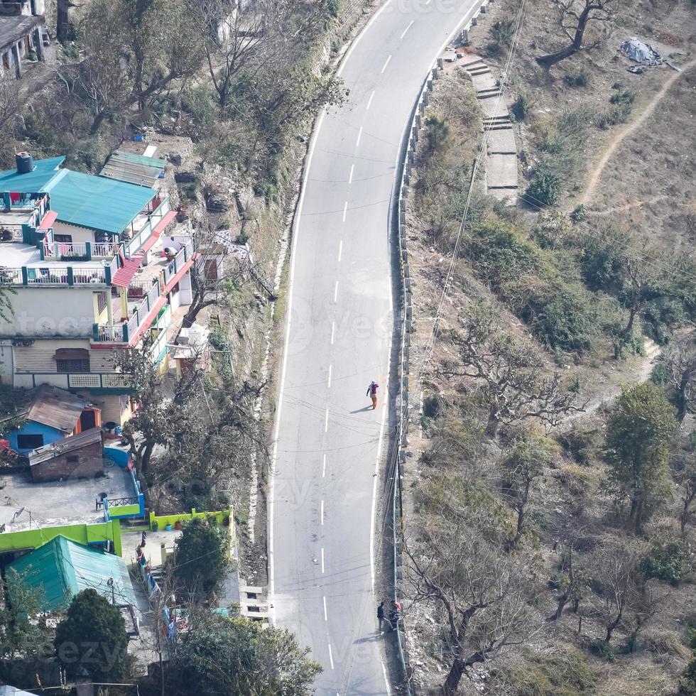 bovenaanzicht vanuit de lucht van verkeersvoertuigen die rijden op bergwegen in nainital, uttarakhand, india, uitzicht vanaf de bovenzijde van de berg voor verkeer van verkeersvoertuigen foto