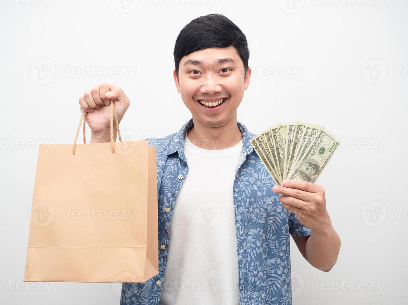 vrolijk Mens gelukkig glimlach Holding boodschappen doen zak met een veel van geld foto