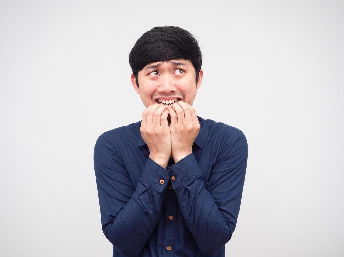 Aziatisch Mens gevoel bang en beet zijn hand- nagel op zoek omhoog portret wit achtergrond foto