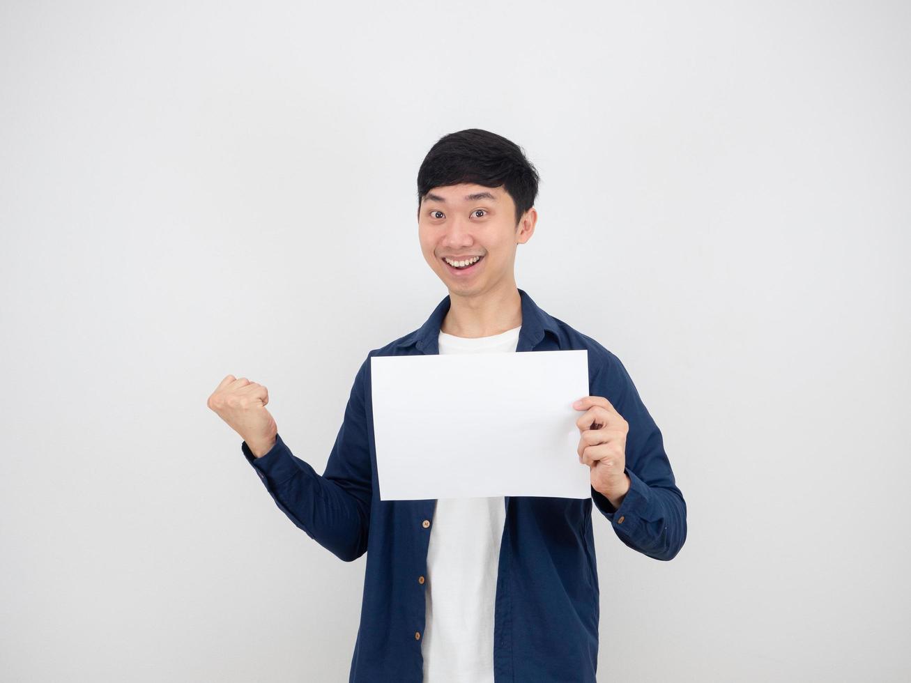 vrolijk Mens Holding leeg papier in hand- en vuist omhoog met gelukkig gezicht en glimlach Aan wit geïsoleerd achtergrond foto