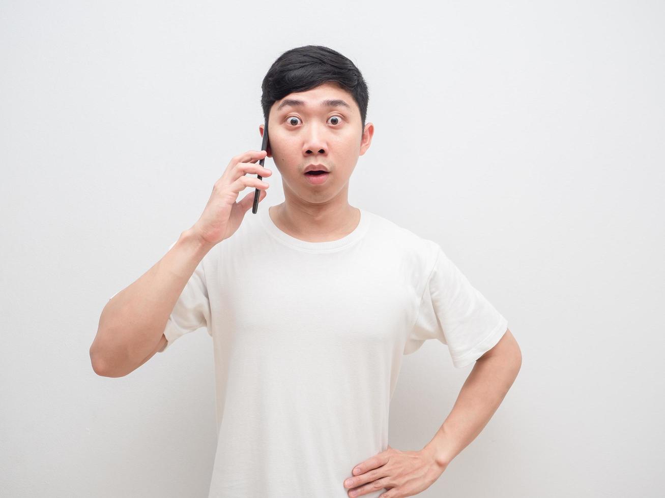 Aziatisch Mens Holding cel telefoon geschokt gezicht kijken Bij camera Aan wit achtergrond foto